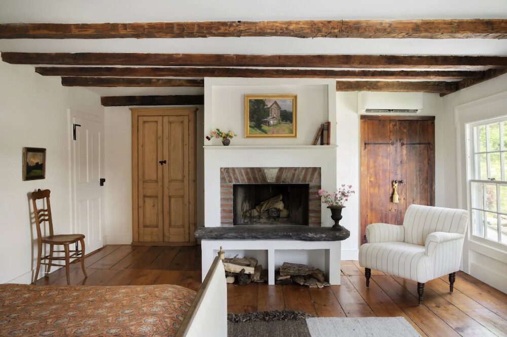 Beadroom hearth with bed and couch chair at 809 North Quaker Hill Road, Pawling NY.