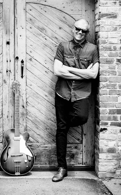 Carl Mateo and Guitar in doorway.