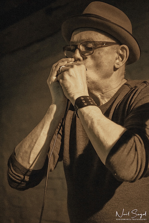 Carl Mateo playing the harmonica.