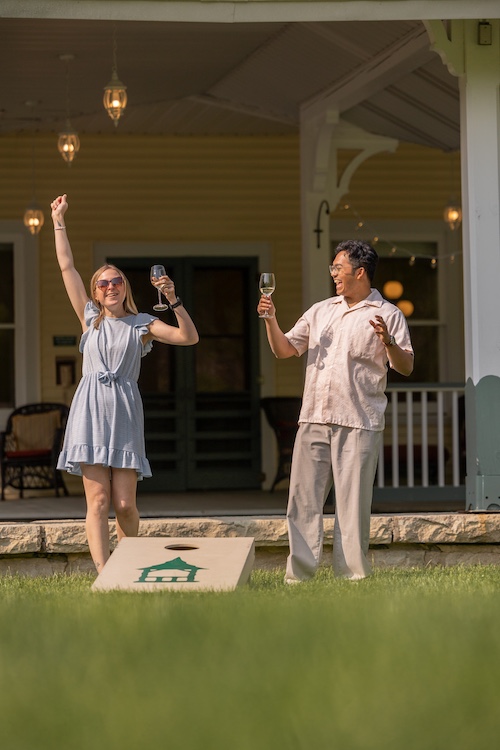 two people playing cornhole with glasses of wine at Hudson Valley Wine Dinners at Mohonk Mountain House in New Paltz NY.