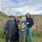 Elizabeth vitner and owner of Stone Ridge Orchards, Becky Collins, Deborah DeWan and County Executive Jen Metzger at the Wassail event with orchards in the background.