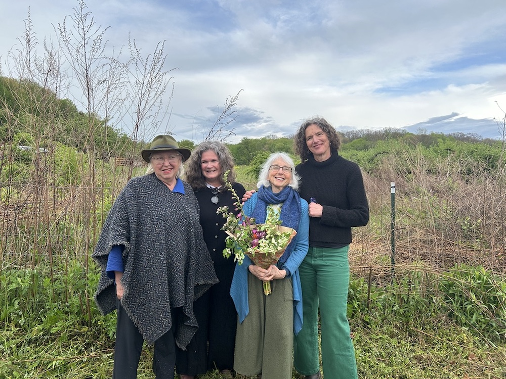 Elizabeth vitner and owner of Stone Ridge Orchards, Becky Collins, Deborah DeWan and County Executive Jen Metzger at the Wassail event with orchards in the background.