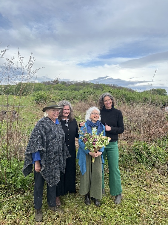 Elizabeth vitner and owner of Stone Ridge Orchards, Becky Collins, Deborah DeWan and County Executive Jen Metzger at the Wassail event with orchards in the background.