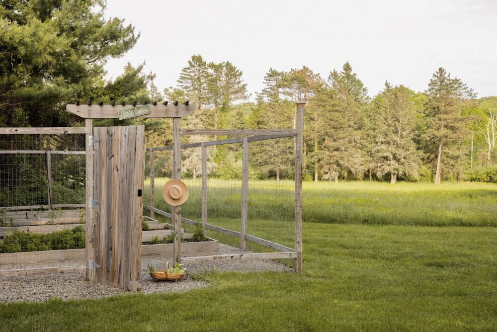 The fence of the garden with a sun hat hanging off the side at 809 North Quaker Hill Road, Pawling NY.
