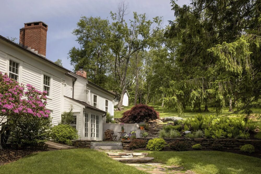 A side view of hte house with a patio at 809 North Quaker Hill Road, Pawling NY.