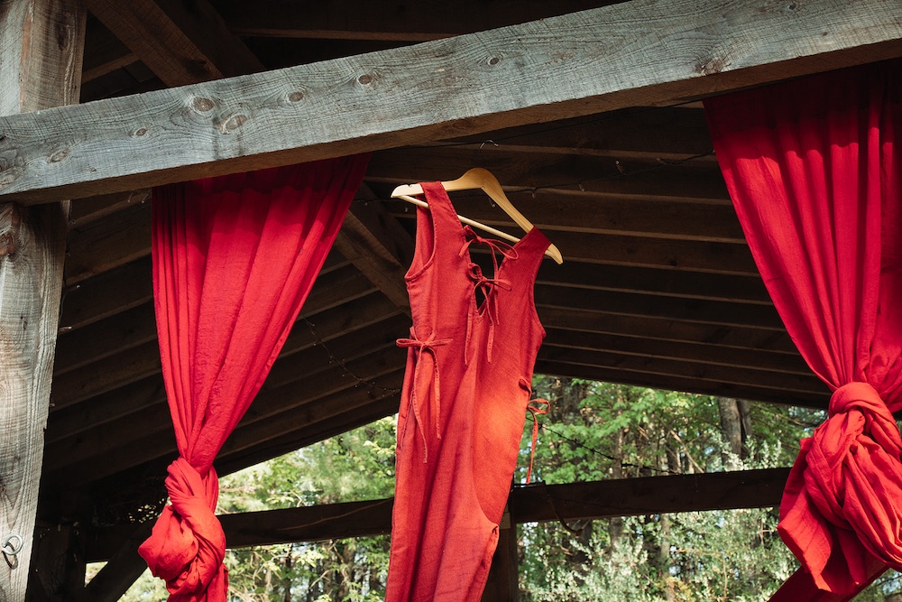 Red curtains and red dress hanging off the beams.
