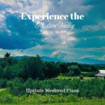 Landscape image of Rose Hil Farm from the top of the hill out past the trees, to the Catskill Mountains and great sky with the "Experience the Hudson Valley" and "Upstate Weekend Plans" text written across the photo.
