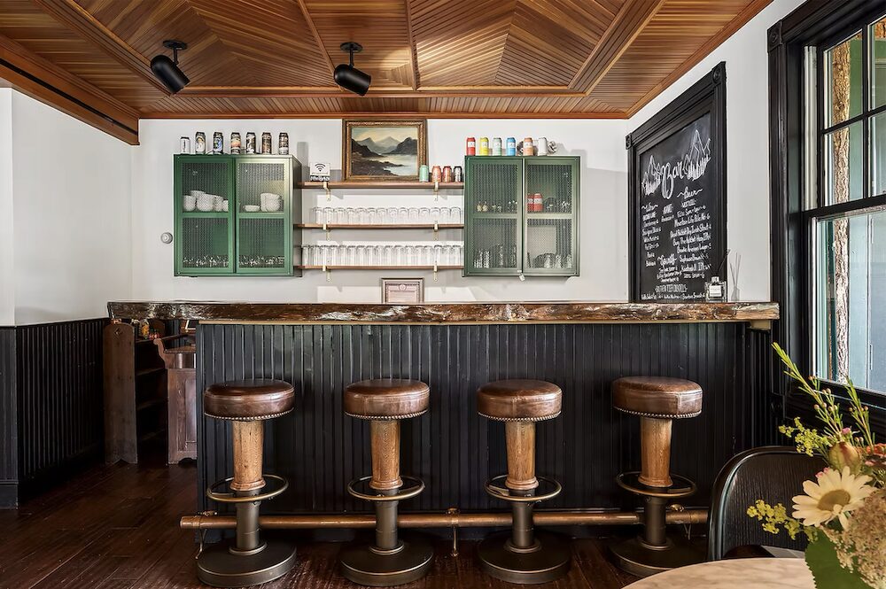 A cute little bar in the lobby with stools at Hotel Mountain Brook in Tannersville NY.