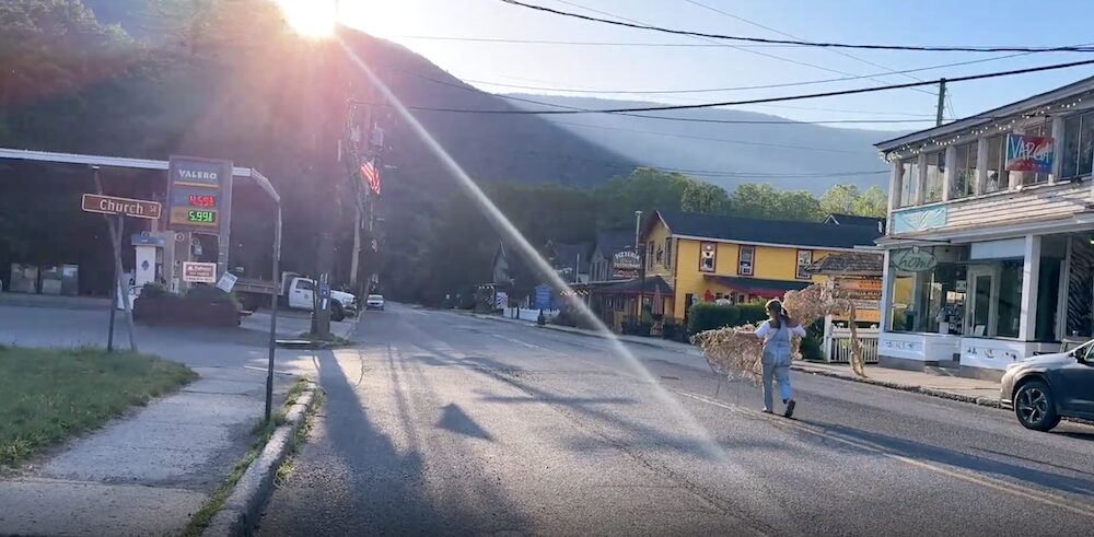  Hudson Valley Artist Christina Varga walking down Main Street Phoenicia with artwork