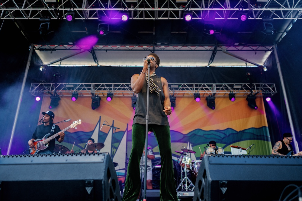 lead singer on stage in Cimafunk Band at the Hudson River Music Festival in Croton Point Park NY.