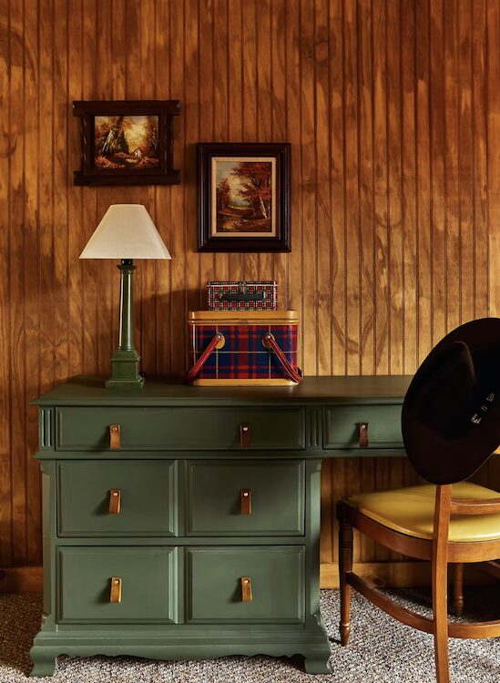A green desk with lamp and chair in cabin at Andes Hotel in Andes NY.
