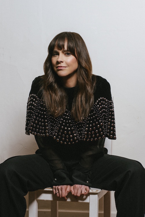 Fiona Dourif sitting on a chair.