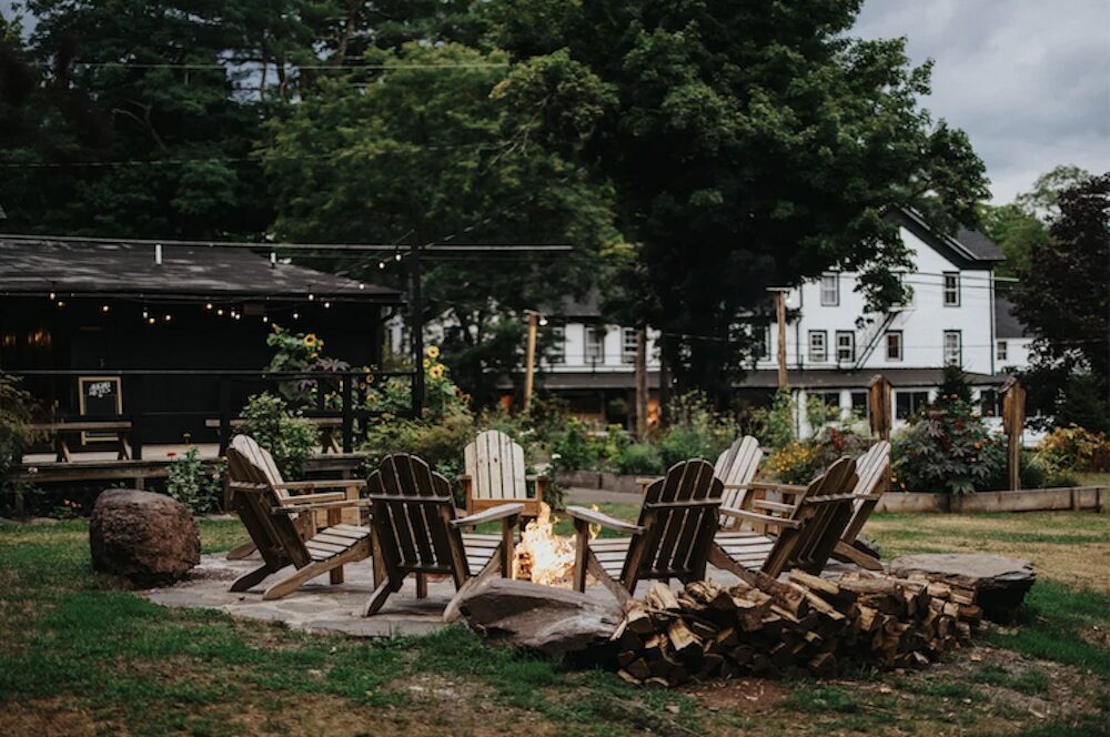 Firepit outside with hotel in the background at Glen Falls House in Round Top NY.