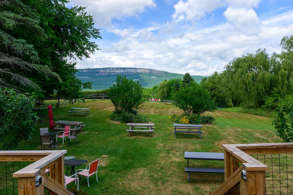 View of the lawn and Gunks mountain cliffs in the background at Whitecliff Vineyard & Winery in Gardiner.