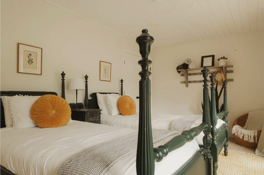 Twin beds with orange flower pillows at 648 Scudder Hill Rd, Roxbury NY.
