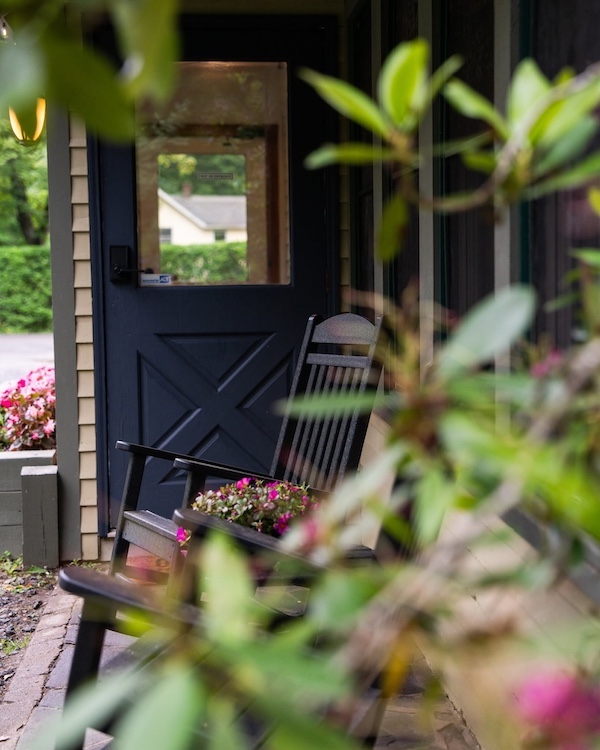 A rocking chair on the porch in front of a cabin at Phoenicia Lodge in Phoenicia NY.