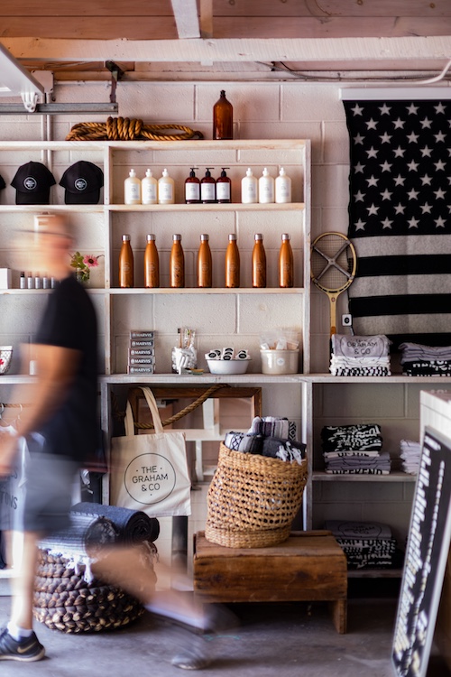 A person walking by in the reception office past shelves of goods at Graham & Co in Phoenicia NY.