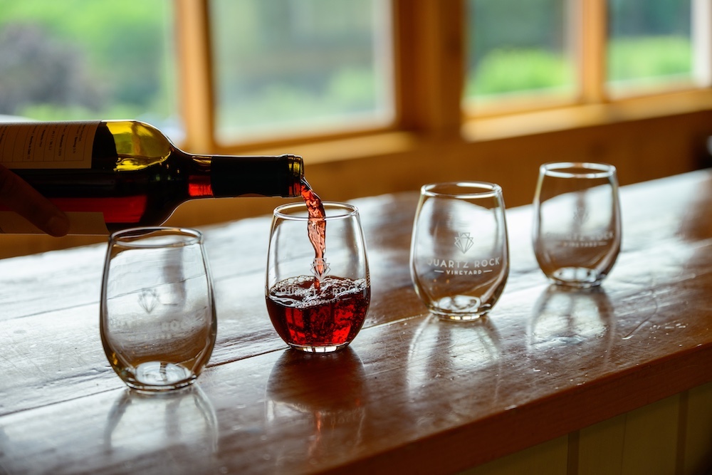 Red Cabernet Franc wine is being poured into a Quartz Rock Winery glass in their tasting room in Marlboro, NY.