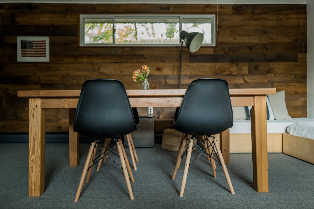 Two black chairs and a wooden table in the cabin at Graham & Co in Phoenicia NY.
