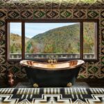 Brass bathtub and view of the mountains through a large window at Urban Cowboy in Big Indian NY.