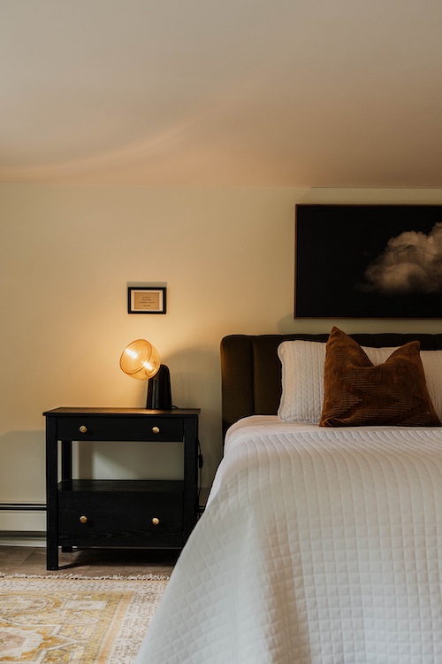 A side table next to the bed with a lamp at Phoenicia Lodge in the Catskills.