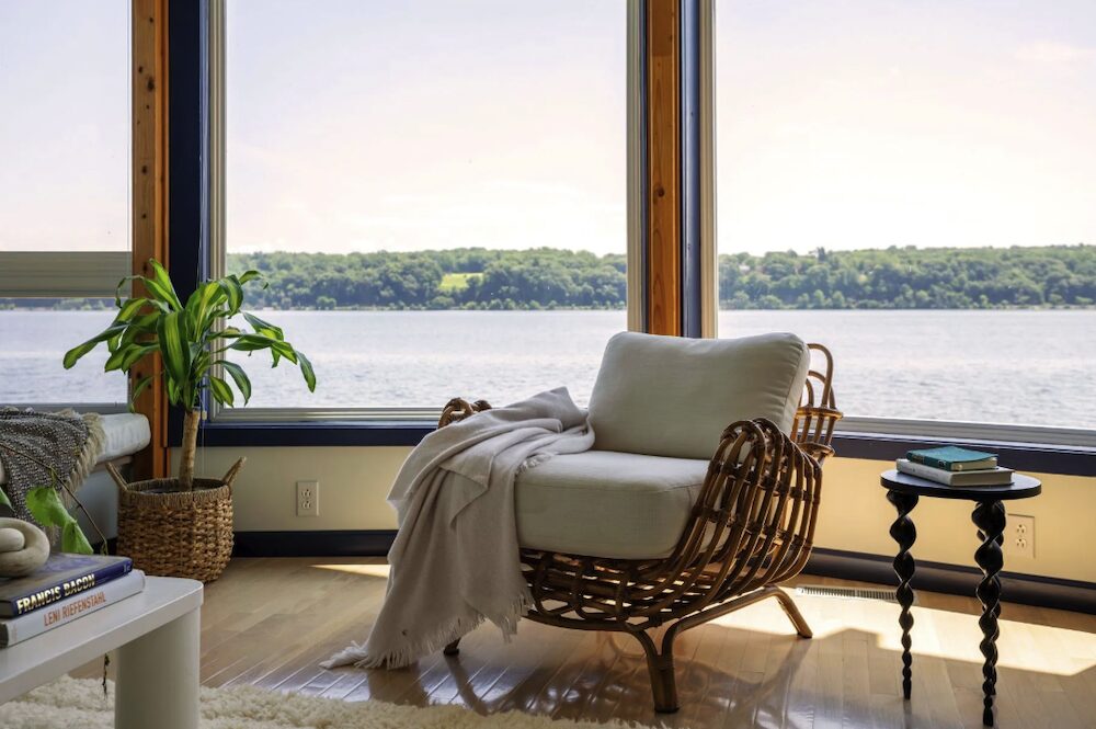 Couch-chair in living room with view of Hudson River in the background at 63 River Road, Malden NY.