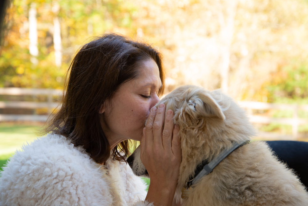 Lisa Bonk of Grateful Pups Training kissing her dog T.