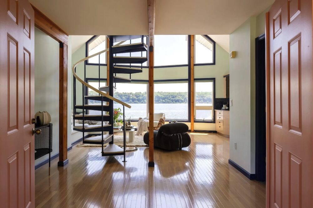Spiral stairs and living space with view at 63 River Road, Malden NY.
