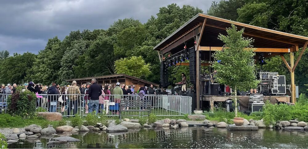 Stage with crowd and pond at Arrowood Farms Brewery & Distillery in Accord NY.